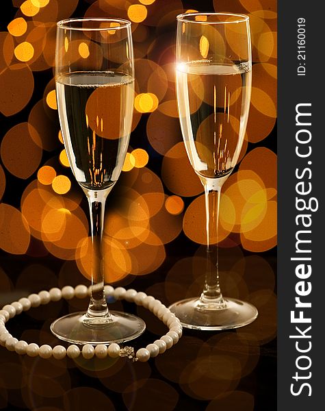Two glasses of champagne with pearl necklace