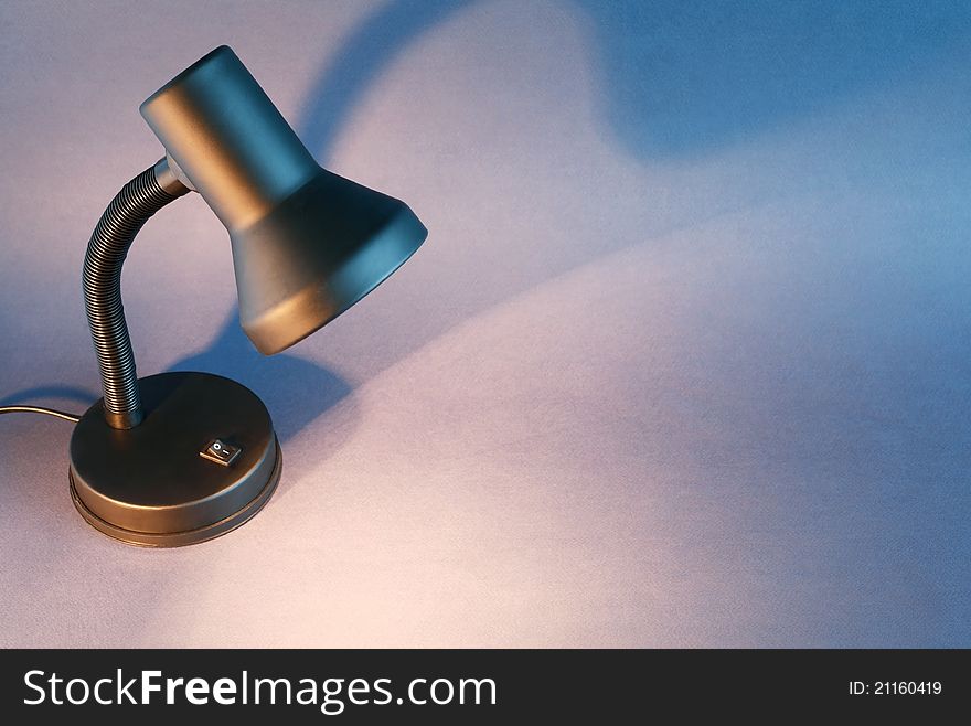 Black luminous desk lamp on dark background with copy space