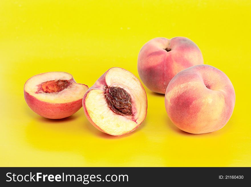 Few peach fruits on yellow background. Few peach fruits on yellow background