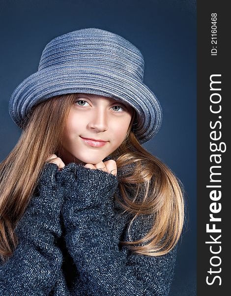 Portrait of a young girl in blue hat and sweater. Portrait of a young girl in blue hat and sweater