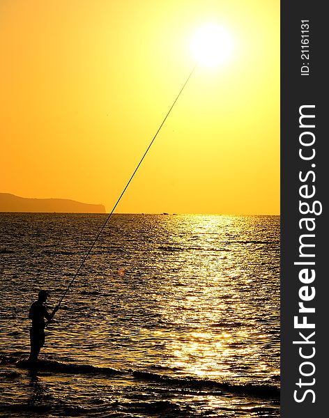 A fisherman at sunset in Sicily