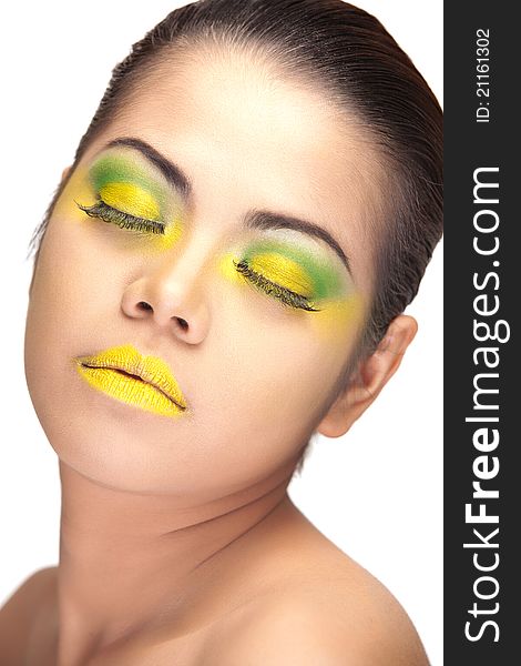 Close up of an Asian female's face wearing yellow and green makeup