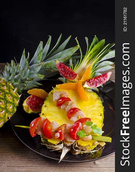 Grilled shrimp spits on ananas decorated with lemon slice, pepper, tomato. Grilled shrimp spits on ananas decorated with lemon slice, pepper, tomato