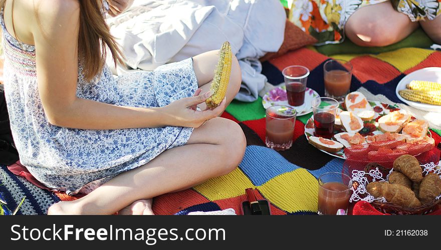 Girl eating sweetcorn at a picnic