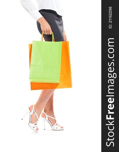 Sexy legs of a woman with shopping bags, white background