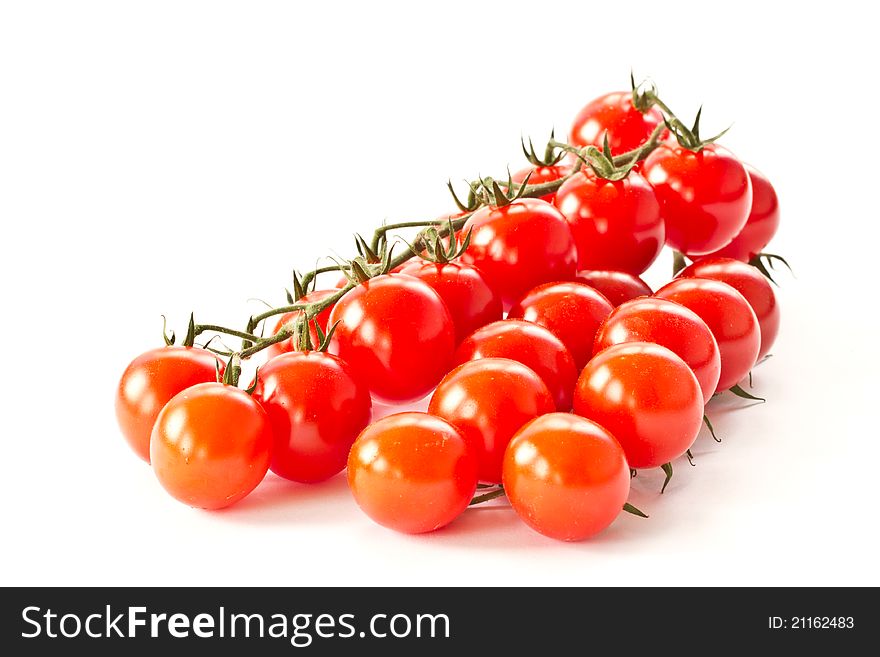 Branch of red cherry tomatoes on a white background