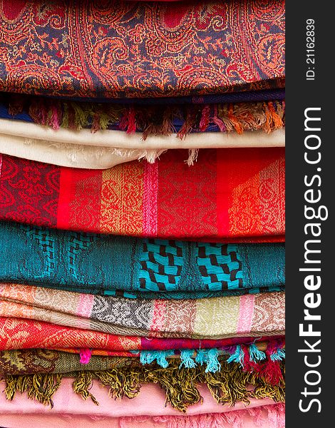 A stack of beautiful colored kashmir scarfs