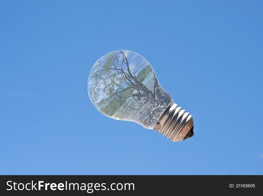 Light bulb with sea landscape inside and sun reflection