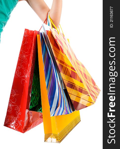 Female hand holding colorful shopping bags on white. Female hand holding colorful shopping bags on white