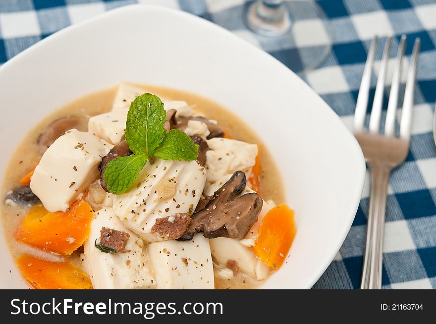 Silky white tofu delicacy in white bowl with healthy ingredients. Silky white tofu delicacy in white bowl with healthy ingredients.