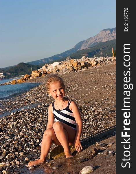 Beautiful girl sitting on a beach at the seashore