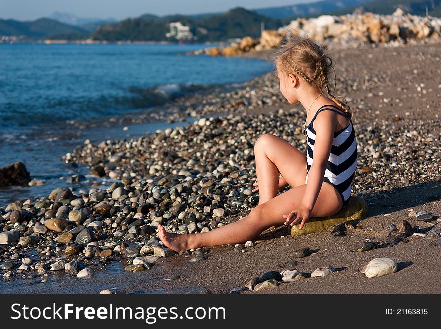 Beautiful Girl Sitting On A Beach