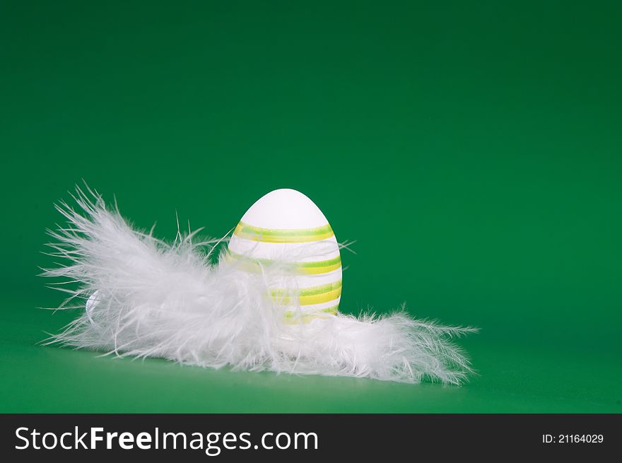 Easter egg is hand painted on white feathers