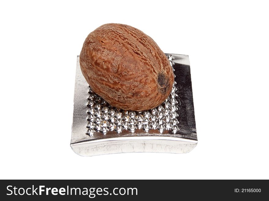 Nutmeg on a grater, fully isolated on white background. Nutmeg on a grater, fully isolated on white background.