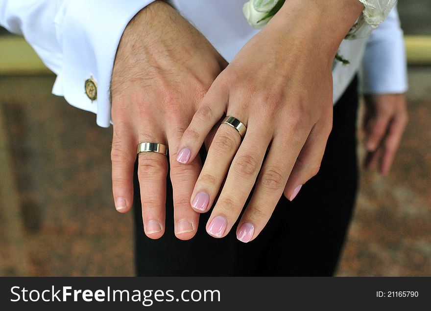 Bride and groom holding hands with wedding rings on it. Bride and groom holding hands with wedding rings on it