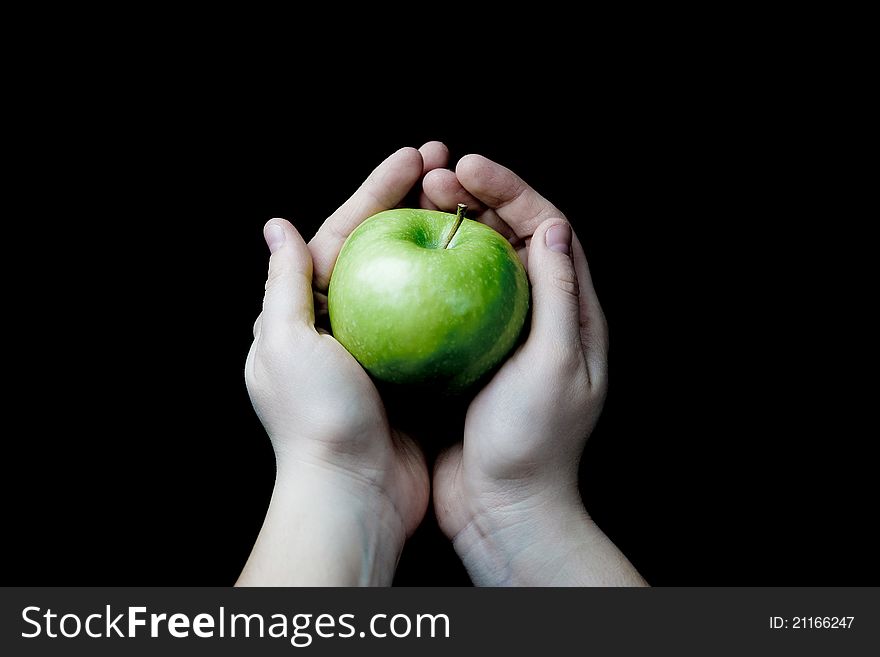 Two hands holding a green apple