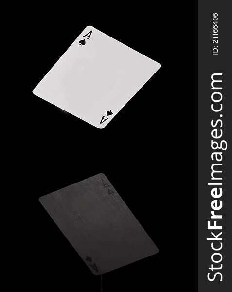 Card falling on black shining surface with reflection