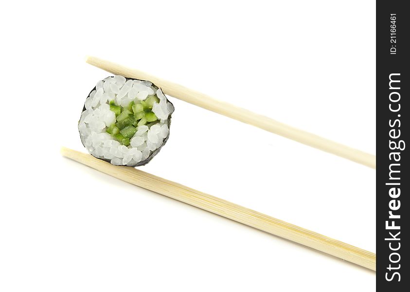 Sushi maki with cucumber between two chopsticks