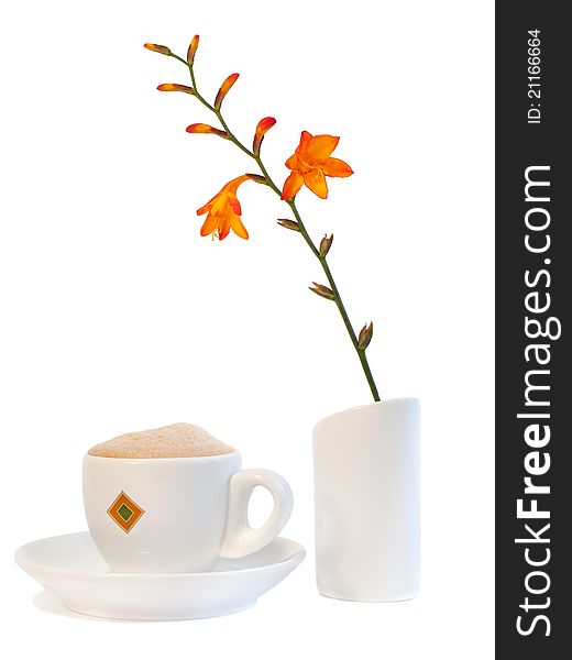 White cup with hot coffee and bright orange flower (Montbretia) isolated on white background. White cup with hot coffee and bright orange flower (Montbretia) isolated on white background.