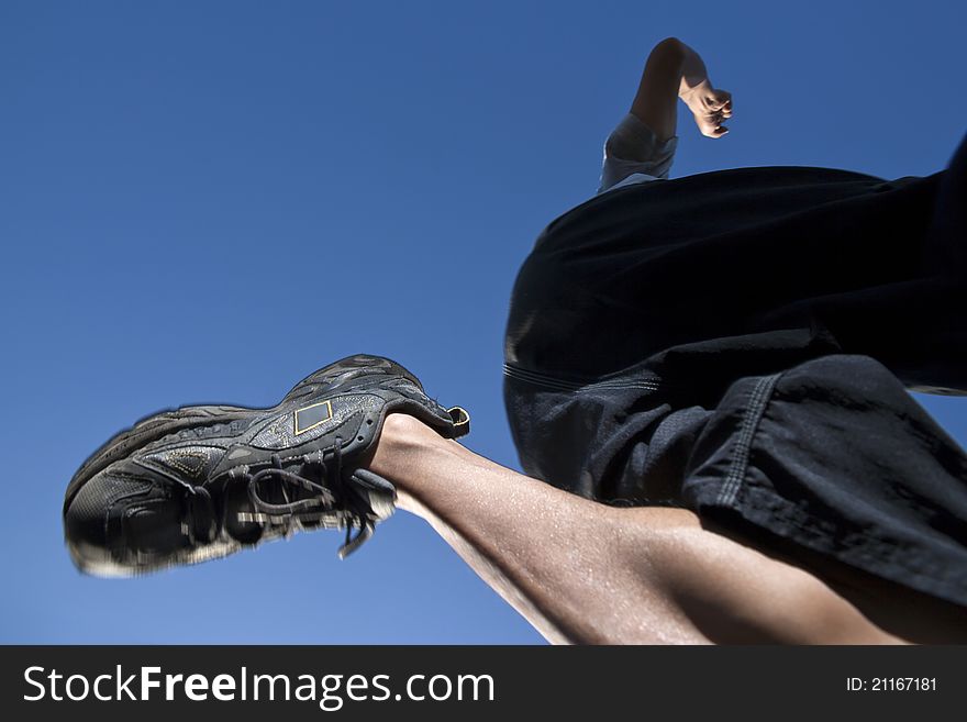 Runner jumping over blue sky