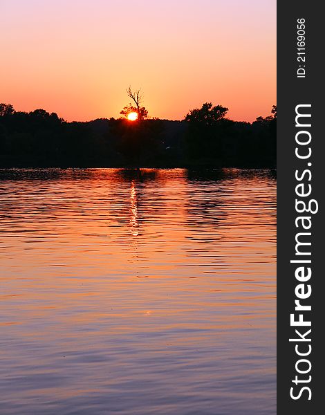 Fiery sunset on the lake in park