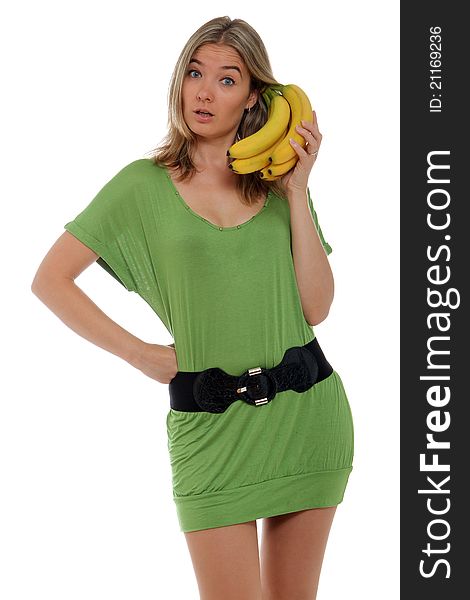 A young woman in green dress talking on a banana phone. A young woman in green dress talking on a banana phone