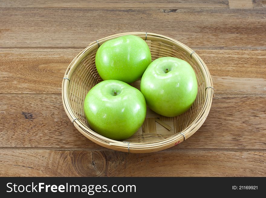 3 Green Apples On Basket With Teak Wood Background