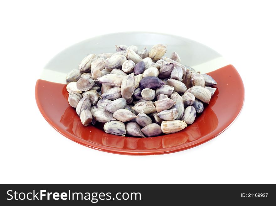 Peanuts on red and gray plate with white background.