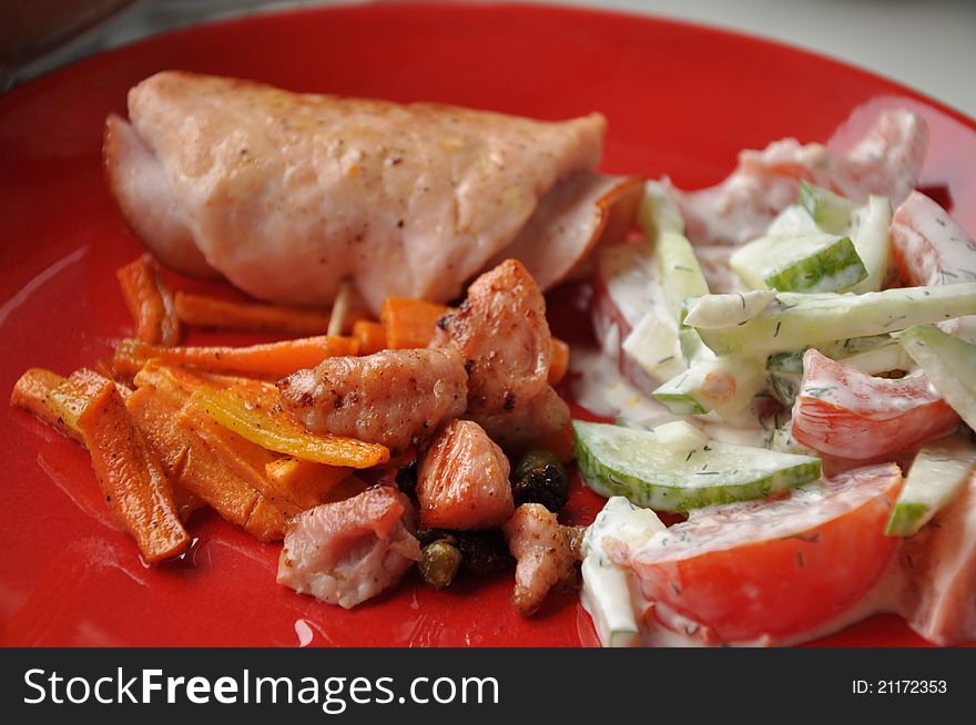 Pork in the roll and the fresh vegetable salad with sour cream. Pork in the roll and the fresh vegetable salad with sour cream.