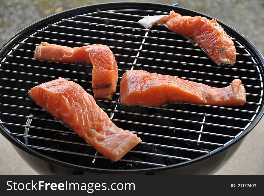 Pieces of salmon on the grill. Pieces of salmon on the grill.