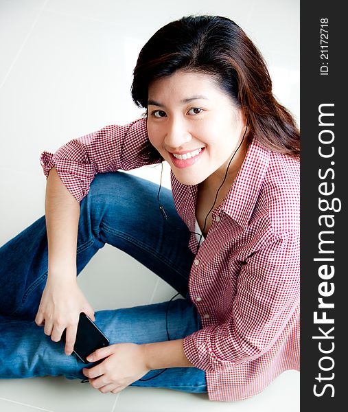 Portrait of beautiful asian woman sitting on the floor with mobile phone. Portrait of beautiful asian woman sitting on the floor with mobile phone