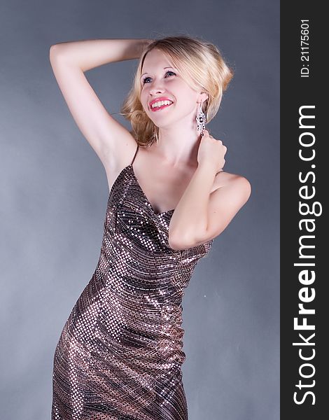 Portrait of a beautiful young blonde woman in shiny dress