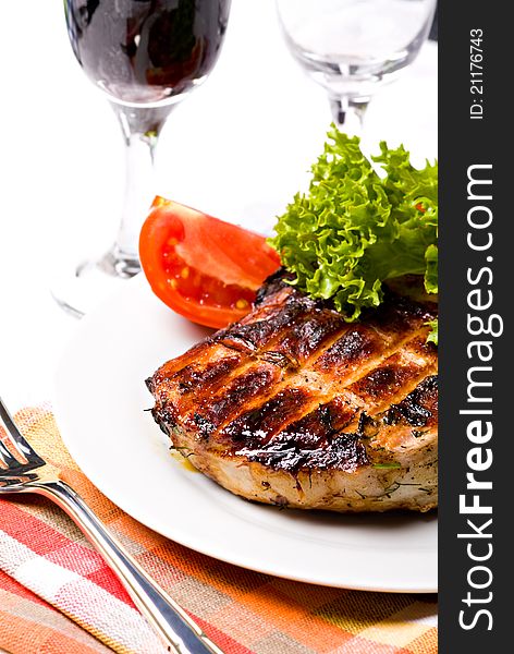 Grilled pork meat on plate with wine