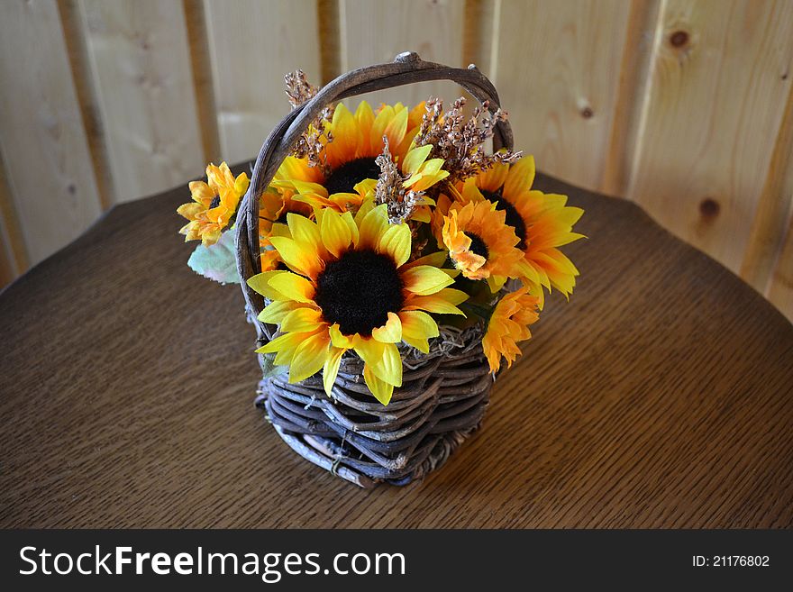 Man-made bouquet of sunflowers in a basket on a table