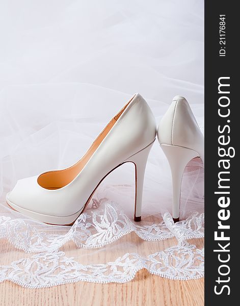 Luxury leather high-heeled shoes for bride and veil, selective focus. Luxury leather high-heeled shoes for bride and veil, selective focus.