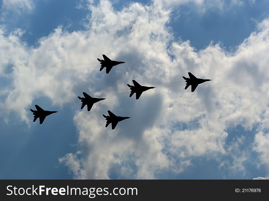 Flight of modern combat fighters on the sky background