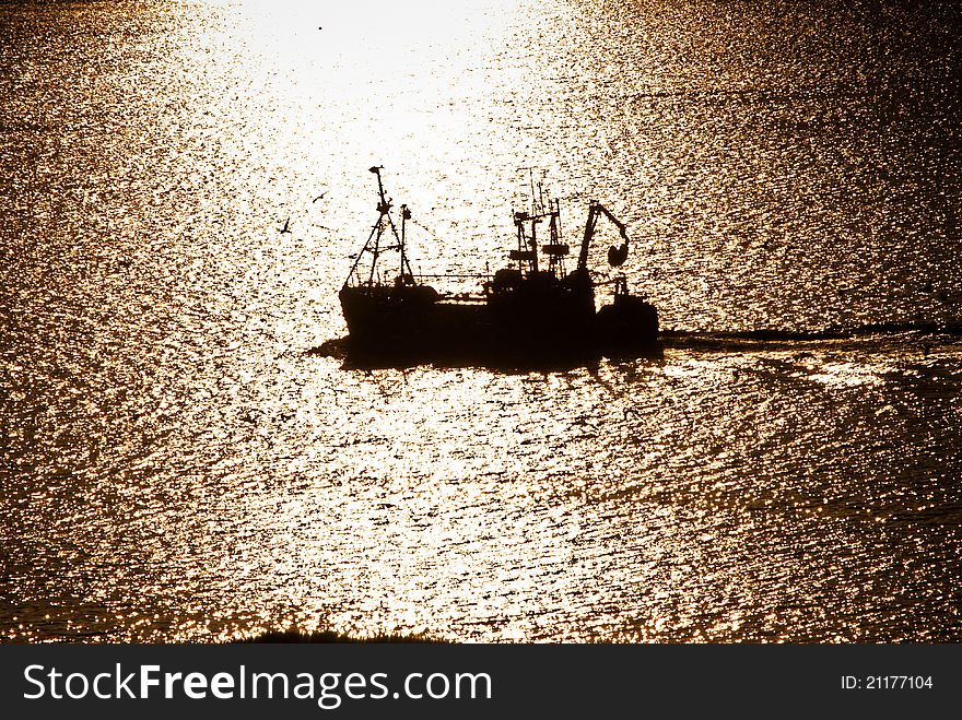 Working fishing boat during sunset