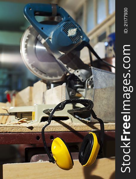 Wood circular saw and protective earphones at plywood manufactory. Wood circular saw and protective earphones at plywood manufactory