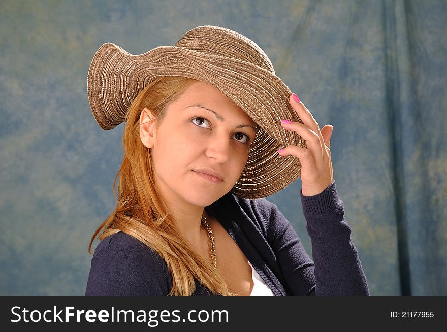 Girl with a summer hat on a blue background. Girl with a summer hat on a blue background