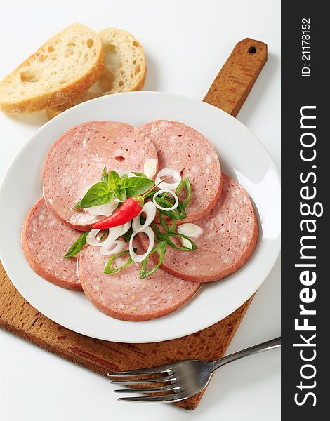 Sliced Mortadella-like sausage sprinkled with spring onion. Sliced Mortadella-like sausage sprinkled with spring onion