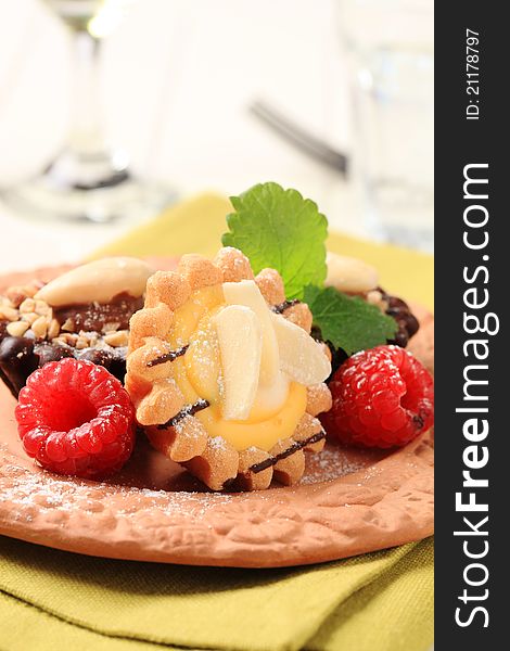 Chocolate and vanilla cream tartlets garnished with raspberries. Chocolate and vanilla cream tartlets garnished with raspberries