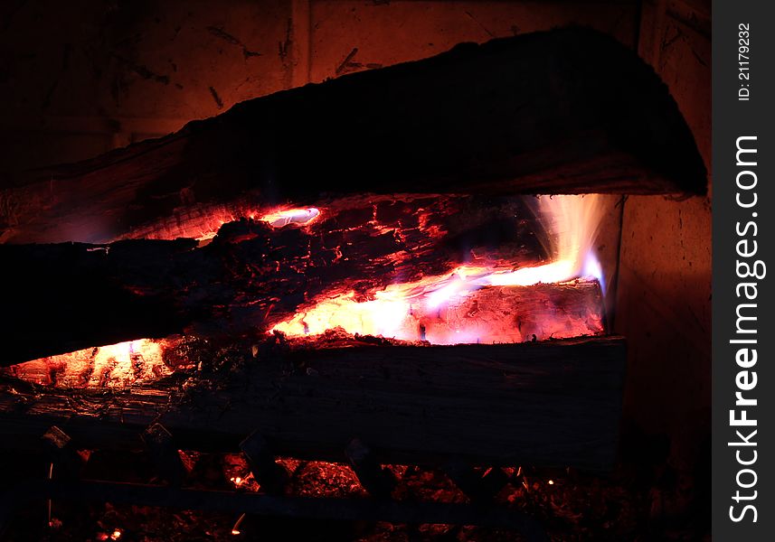 Burning wood with glowing embers.