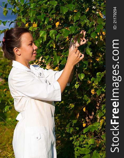 Young doctor woman with clear water in test-tube outdoors. Young doctor woman with clear water in test-tube outdoors