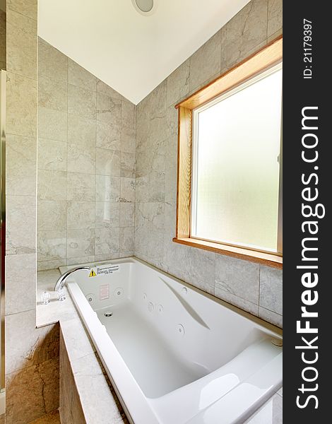 White Tub With Large Window And Tiles.