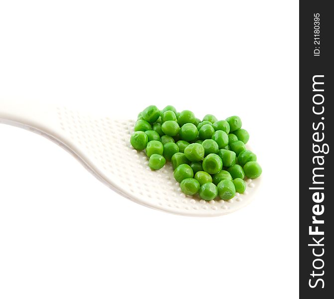 Cooked green peas in  spoon on white background