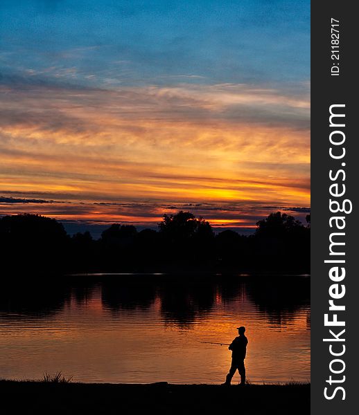 Fisherman at sunset in the orange and blue colors