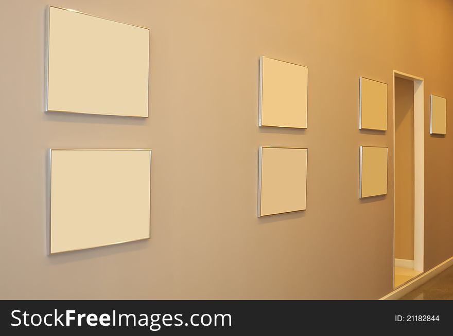 Frames decorated on wall in tungsten light.