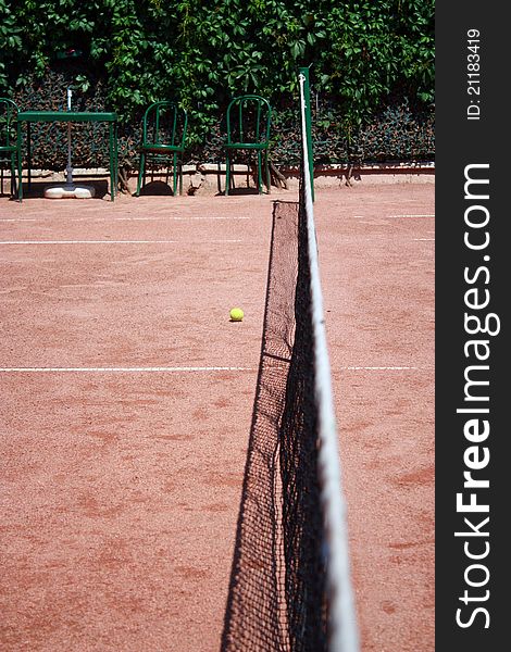 Slag tennis field with net and ball