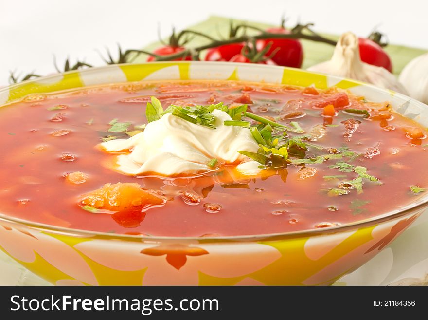 Fresh hot beet borscht with sour cream and herbs