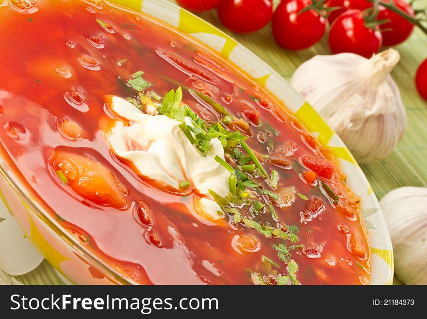 Fresh hot beet borscht with sour cream and herbs